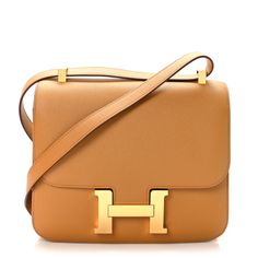 This is an authentic HERMES Epsom Constance 24 in Sesame. This stylish shoulder bag is finely crafted of epsom calfskin leather in golden brown. The bag features a brown shoulder strap with goldplated hardware including an H buckle at the frontal flap. The flap opens to a matching partitioned leather interior with a zipper pocket. Hermes Constance Bag, Hermes Constance, Stylish Shoulder Bag, Hermes Bags, Golden Brown, Leather Interior, Zipper Pocket, Calf Skin, Duffle Bag