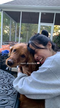 a woman is hugging her dog outside