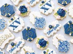 blue and white decorated cookies are arranged on a marble countertop with the names of each cookie