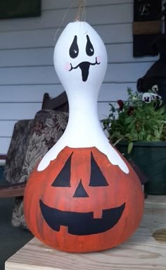 a pumpkin shaped like a ghost sitting on top of a wooden table