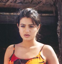 a young woman in a colorful dress posing for the camera with her hand on her hip