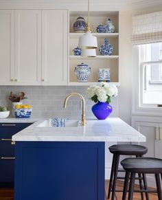 a kitchen with blue and white decor on the cabinets, counter tops, and stools