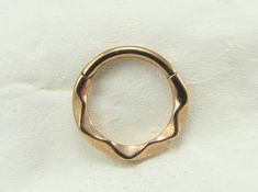 a gold ring is shown on a white surface with no other object in the background