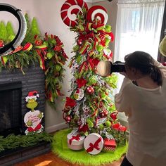 a woman is decorating a christmas tree with candy canes and decorations on it