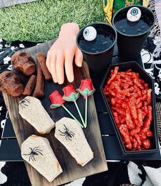 a table topped with lots of food on top of a black tray covered in spider webs