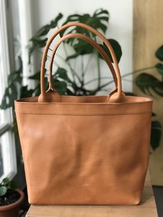 Beautiful leather bag, made with the highest quality veg tanned leather. Its clean design makes this beautiful bag a versatile every occasion bag. FEATURES: - Highest quality Full Grain Veg Tanned leather - Aprox size: 12.6 - 15.7 inches wide (32-40 cm) 11.8 inches high (30 cm) 5 inches deep (13 cm) - Inside lining with 3 inside pockets and 1 zippered pocket - Drop of the straps: 7 in aprox (17 cm). Distance from top of the bag to the shoulder where the straps rest. We can make it with longer ha Classic Dark Tan Shoulder Bag For Everyday Use, Classic Dark Tan Bag For Everyday Use, Classic Soft Leather Bag In Camel, Classic Dark Tan Bags For Daily Use, Modern Light Brown Bags For Everyday Use, Classic Light Brown Satchel For Everyday Use, Classic Light Brown Bag For Everyday, Classic Light Brown Everyday Bag, Classic Light Brown Everyday Bags