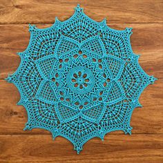 a blue doily sitting on top of a wooden floor