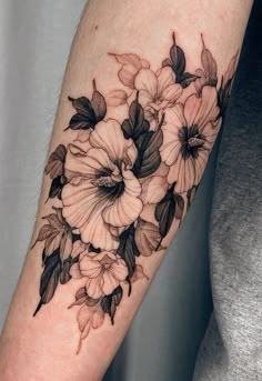 a black and white flower tattoo on the arm