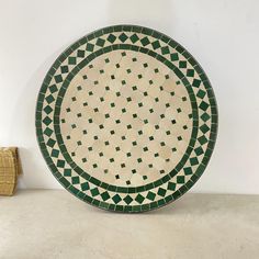 a green and white plate sitting on top of a table next to a wicker basket