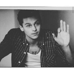 a black and white photo of a young man making the vulcan sign