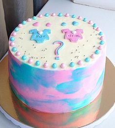 there is a cake that has pink and blue frosting on the top with decorations