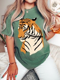 "Tiger Comfort Colors® Shirt, Tiger Tropical Jungle Tshirt, Tiger Women Gift, Women Tiger Shirt, Tiger Tshirt for Women, Tiger Lover T-shirt WELCOME TO BUTIKCHI  This is a standard unisex size Comfort Colors Tee. For an oversized tee, please size up. Please review the size chart to ensure you receive the fit you want. How to Order?  Please, choose your favorite color and size from the pop-up window. Select the quantity that you want. Click \"ADD TO CART\". You can go back to add more product col Green Crew Neck Birthday Shirt, Green Graphic Print T-shirt For Birthday, Green Short Sleeve Birthday T-shirt, Printed Crew Neck Top For Birthday, Green Graphic Print Top For Birthday, Green Short Sleeve Shirt For Birthday, Printed Short Sleeve Tops For Birthday, Birthday Short Sleeve Printed Tops, Safari Shirts