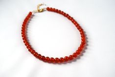 "Carnelian is a lovely semi-translucent stone in a rich orangey red color. It is highly polished for a beautiful shining quality. The stones themselves are a larger size- about 8mm around- so this is a necklace that will make a nice statement. The necklace is 15\" long with a 2\" extender chain, or it can be finished with two rings in the 18th Century style. This allows you to run a ribbon of your choice through the rings and tie it tightly on the neck, like a choker, or loose so it hangs down l Red Carnelian Faceted Beaded Necklaces, Red Carnelian Beaded Necklace With Faceted Beads, Red Carnelian Hand-strung Beaded Necklaces, Red Carnelian Beaded Necklace Hand-strung, Hand-strung Red Carnelian Beaded Necklaces, Handmade Red Carnelian Beaded Necklaces, Red Carnelian Beads For Gift, Red Carnelian Beads For Gifts, Spiritual Red Carnelian Beads