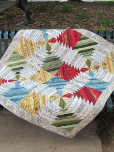 a quilted table top sitting on a park bench