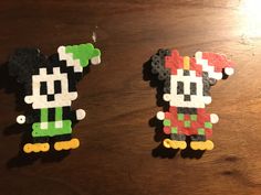 two mickey and minnie mouse magnets sitting on top of a wooden table