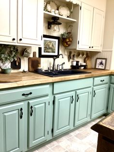 a kitchen with green cabinets and white cupboards