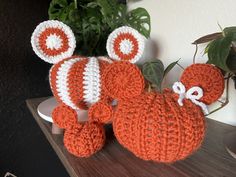 an orange and white crocheted stuffed animal sitting on top of a wooden table