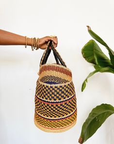 A beautiful authentic one-of-a-kind handwoven market basket tote handmade in Bogatanga. Each bag is beautifully woven by hand with thick, natural and dyed elephants grass to create a beautiful pattern and leather wrapped handles. This is the perfect market bag for trips to the farmers market, the beach, picnics or storage. Size: 13”H x 17”W x 10”D *One-of-a-kind, 1 of 1. Cowrie Shell Jewelry, Beach Picnics, African Dolls, African Market, Market Basket, Basket Tote, Market Baskets, African Masks, Market Tote