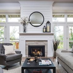 a living room filled with furniture and a fire place in front of a white fireplace