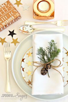 a place setting with napkins, silverware and christmas decorations