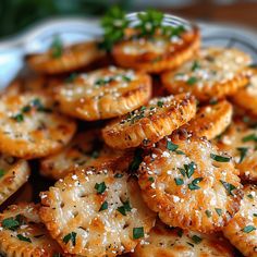 small crackers with parmesan cheese and herbs on top are served in a bowl