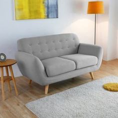 a living room scene with focus on the couch and rug, which also features a lamp