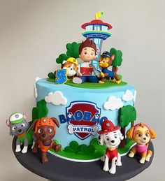 a birthday cake decorated with cartoon characters on it's sides and the top tier is blue