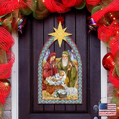 a nativity scene painted on the front door of a house with christmas decorations around it