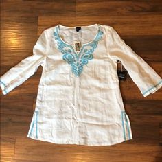 100 Percent Linen Beach Tunic. White With Blue Embroidery Detail. Blue Bohemian Tops For Vacation, Blue Tops For Summer Holiday, Floral Embroidered Tops For Beach Season Vacation, Blue Embroidered Top For Vacation, Beach Tunic, Swim Cover Up Dress, Coverup Skirt, Bathing Suit Covers, Bathing Suit Cover Up