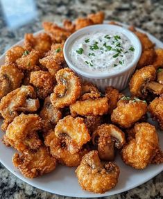 a white plate topped with tater tots covered in ranch dressing