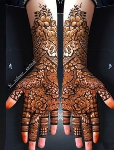 two hands with henna designs on them