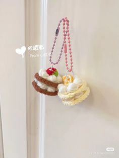 two small cakes hanging from a hook on a wall