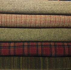 a stack of different colored plaid fabric on top of each other in various sizes and colors