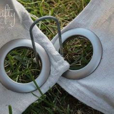 two grey rings are sitting in the grass next to a white cloth on top of it