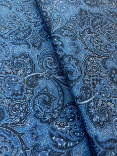 the blue and black paisley pattern is shown on this fabric, which has been folded over