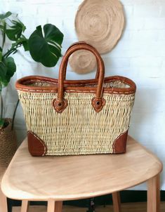 a wicker bag sitting on top of a wooden table next to a potted plant