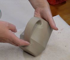 someone is making a vase out of clay