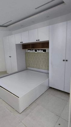 an empty bedroom with white cabinets and a mattress on the floor in front of it