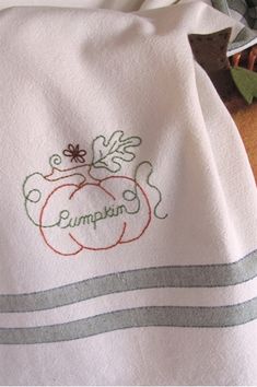 a white towel with an embroidered pumpkin on it