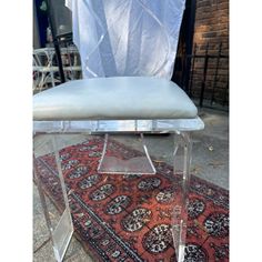 a clear chair sitting on top of a rug