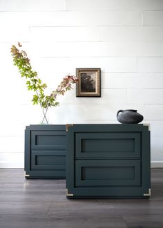 two dark green cabinets in front of a white wall