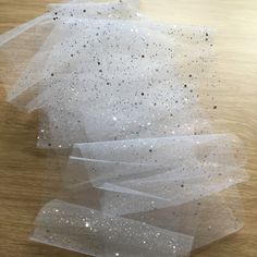 several pieces of white tulle sitting on top of a wooden table