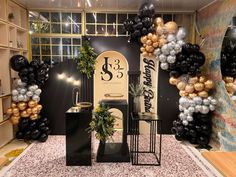 a room filled with balloons and decorations in black, white, gold and silver colors