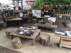 an outdoor living area with wooden furniture and pots on the stove top in front of it