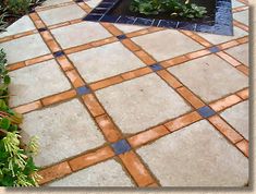 an outdoor patio with plants and flowers in the center, surrounded by stone pavers