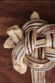 an arrangement of sliced bananas on a wooden table with some brown and white stripes in the middle