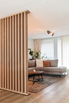 a living room with wooden slats on the wall and a couch in front of it