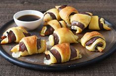 several pastries on a plate with dipping sauce