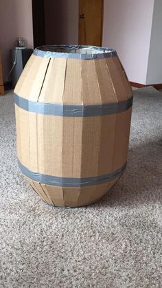 a cardboard barrel sitting on top of a carpeted floor