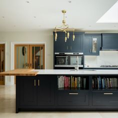 a kitchen with an island and bookshelf in the middle, surrounded by blue cabinets